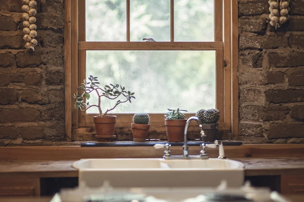 wood framed kitchen window above a sink