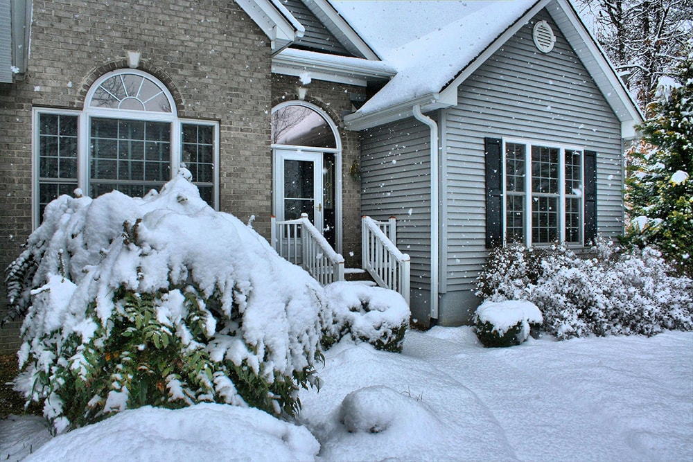 house with snow falling