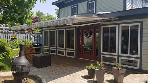 retractable awning installed on house with red door