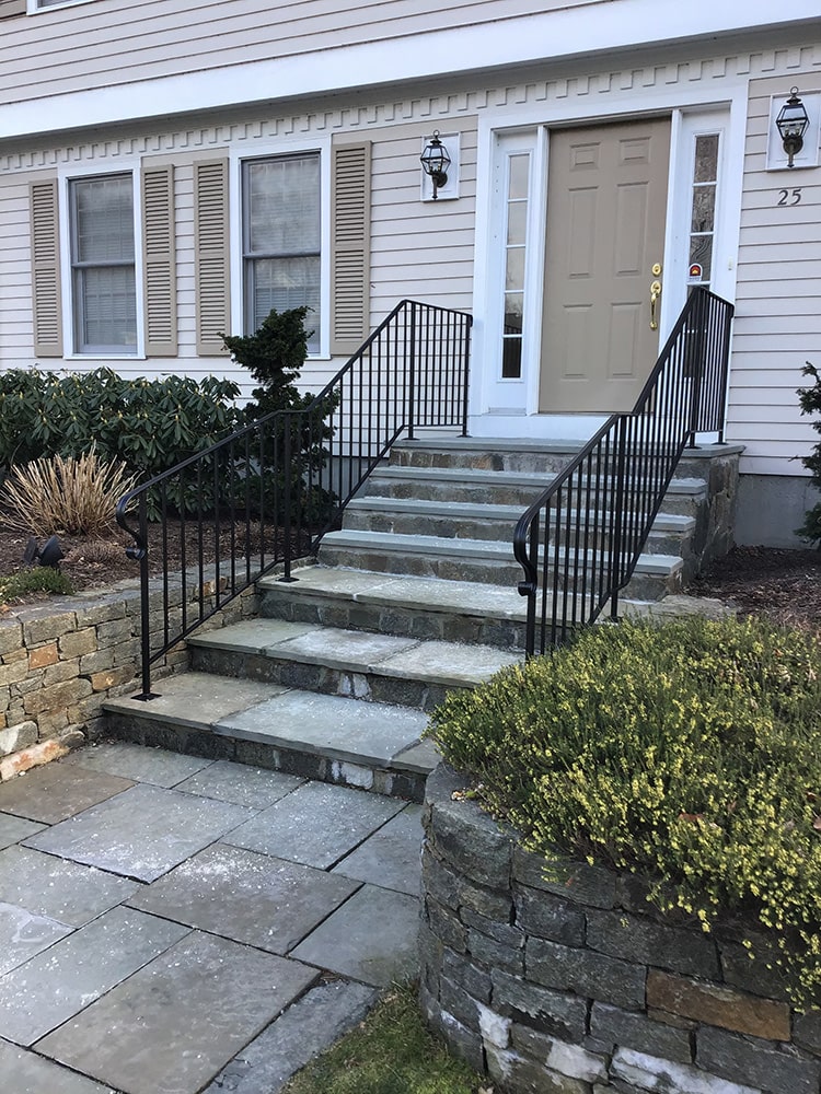 right angle of new wrought iron railing on tan house