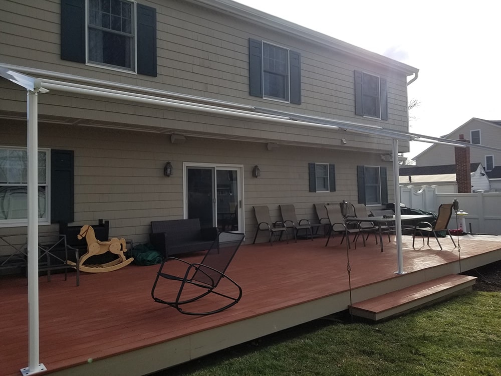 green retractable awning installation on yellow house