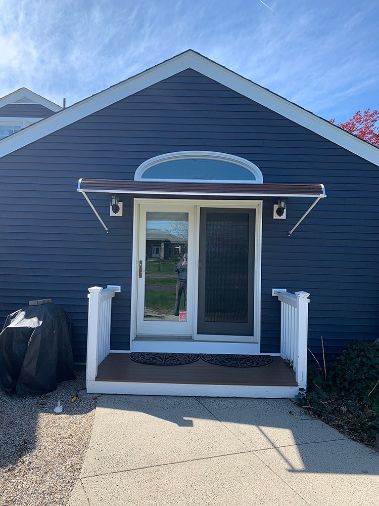 aluminum door canopy on blue house with white trim