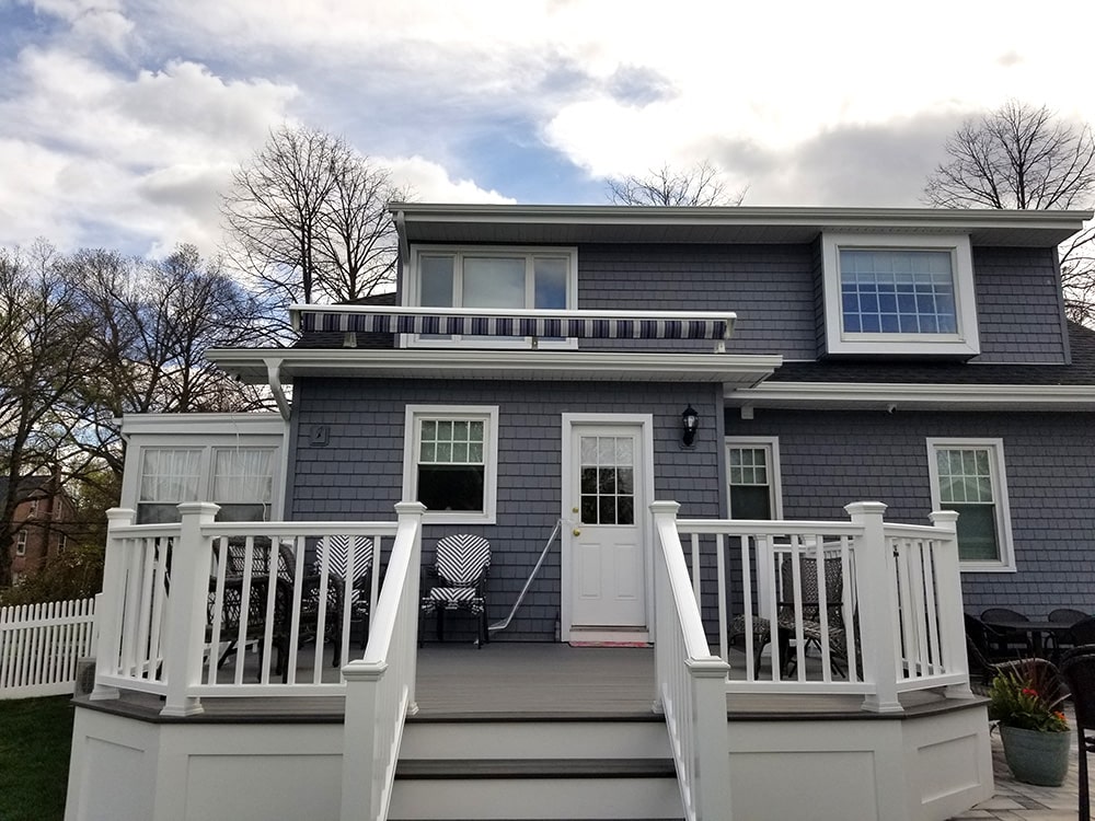 blue and white striped retractable awning installed above porch