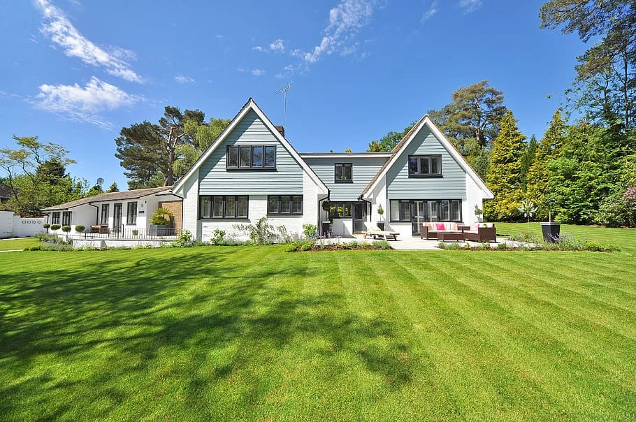 modern house on large property with green grass and welcoming outdoor patio