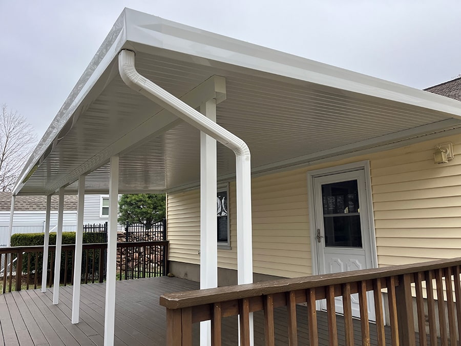 patio cover installed on a yellow house with white accents
