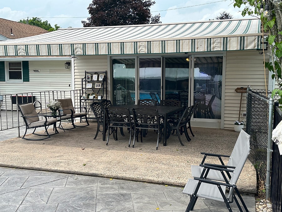 green on tan retractable awning covering patio