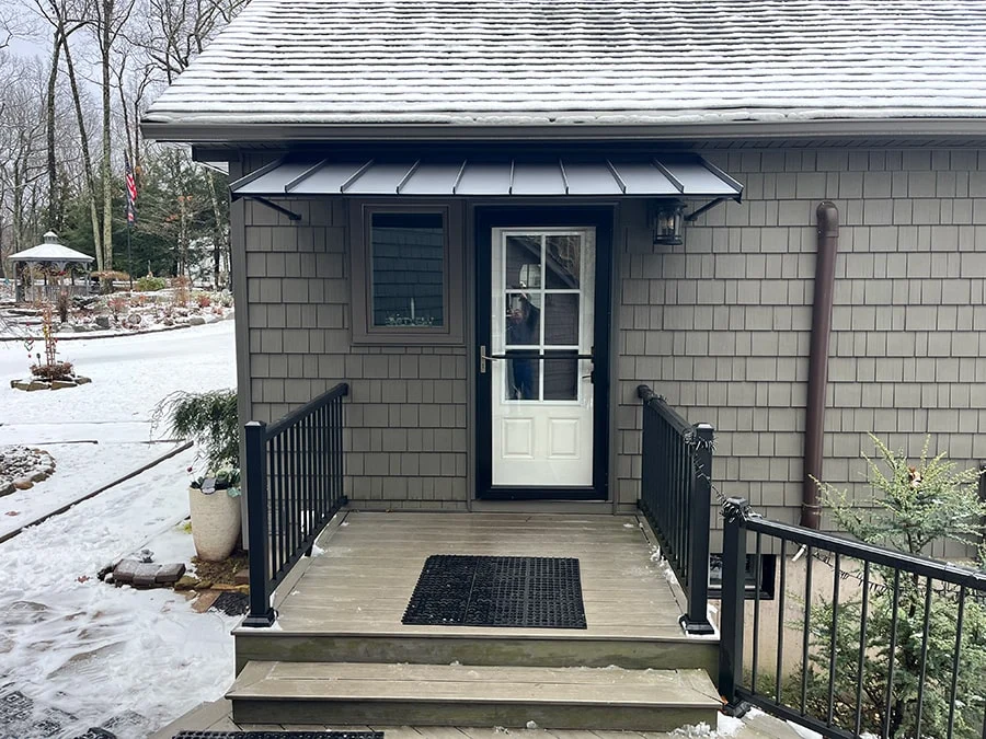 black aluminum door canopy installed over a white door