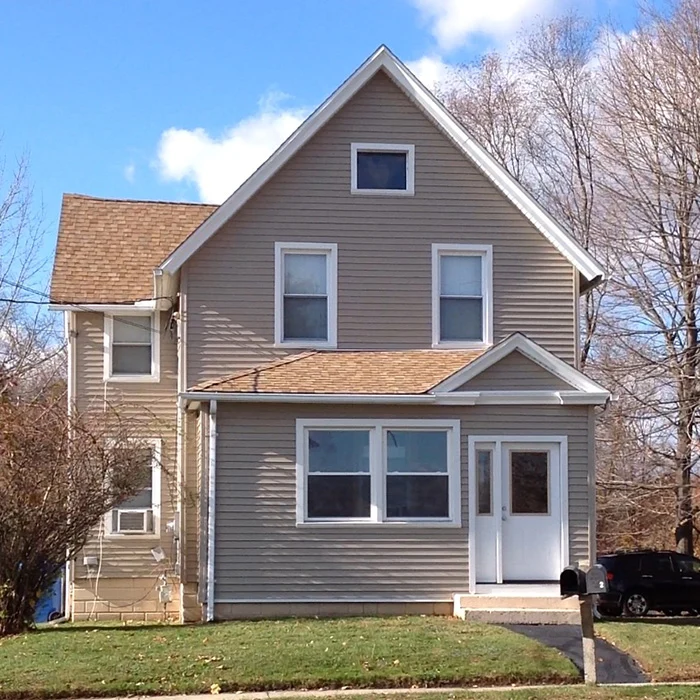 house with new vinyl windows, siding, and gutters