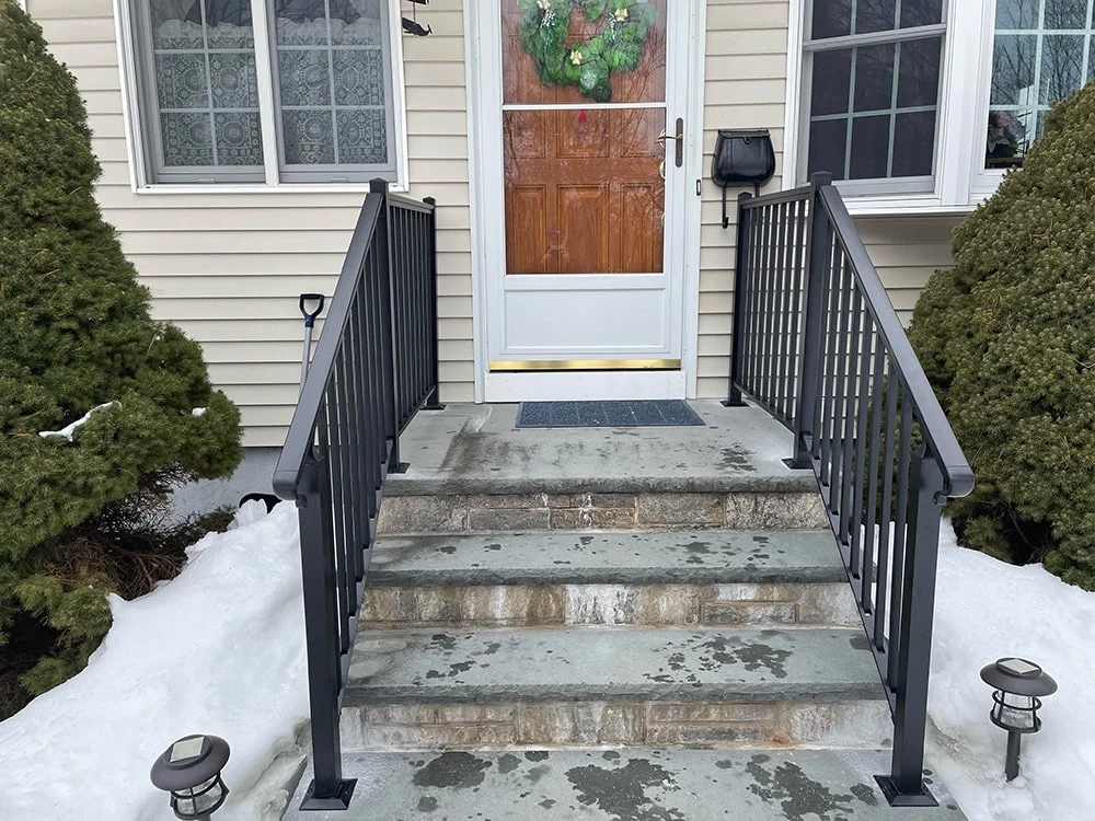 entry door with a wreath hanging and snow on the ground