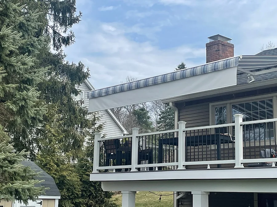 blue and white retractable awning installed over a deck patio