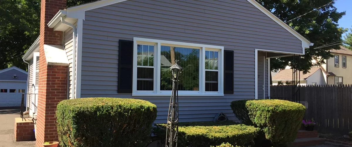 house with gray vinyl siding, windows, and gutters from Aladdin Inc