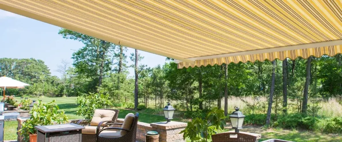 yellow striped retractable awning over an outdoor seating area