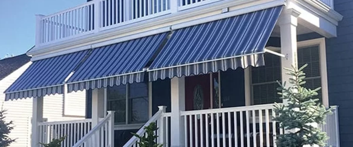 blue fabric window awning with white stripes covering a large porch