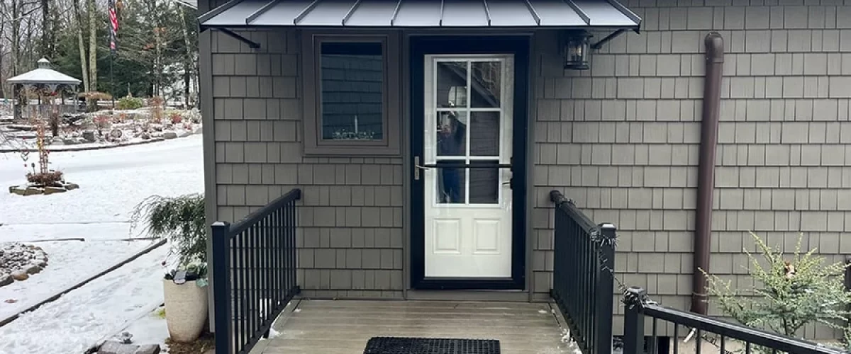 black aluminum door canopy installed over a white door