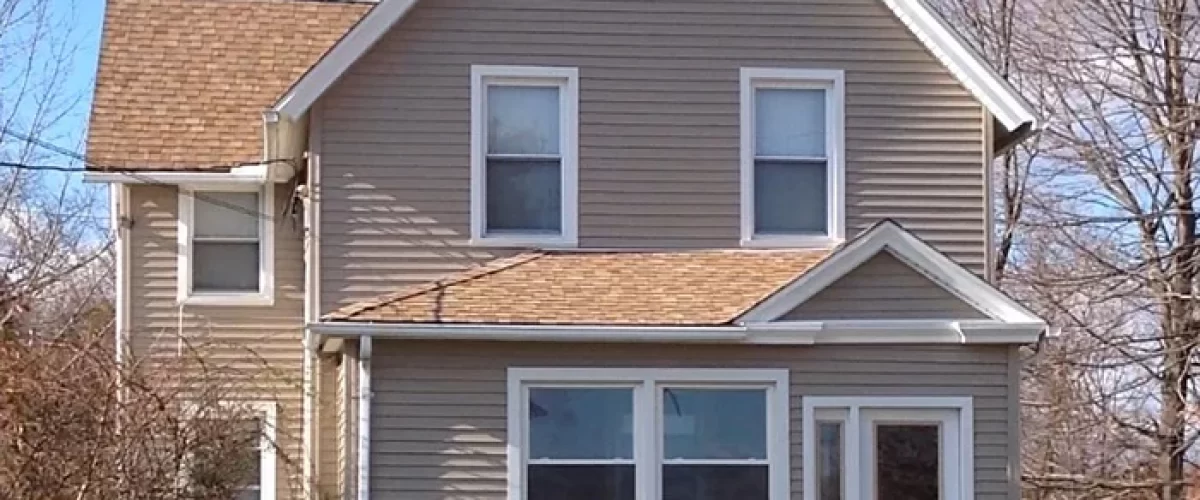 house with new vinyl windows, siding, and gutters