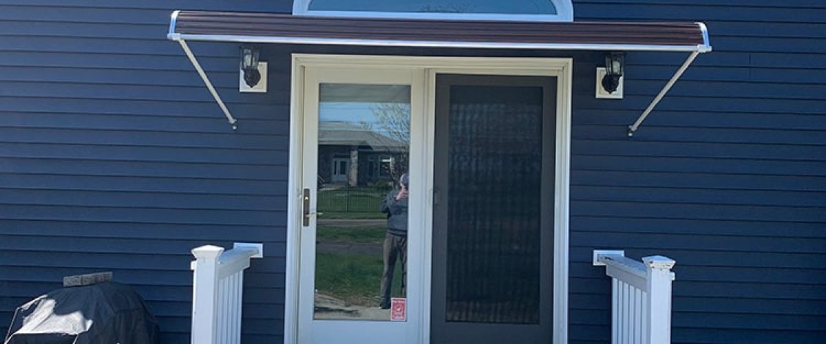 aluminum door canopy on blue house with white trim