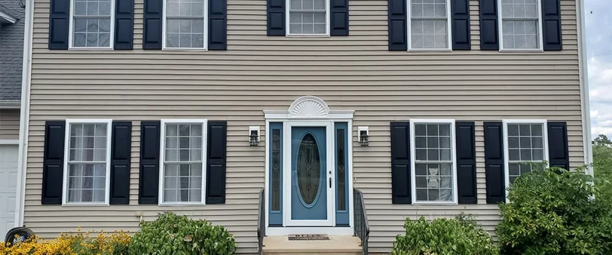 blue entry door on a tan home with glass side panels