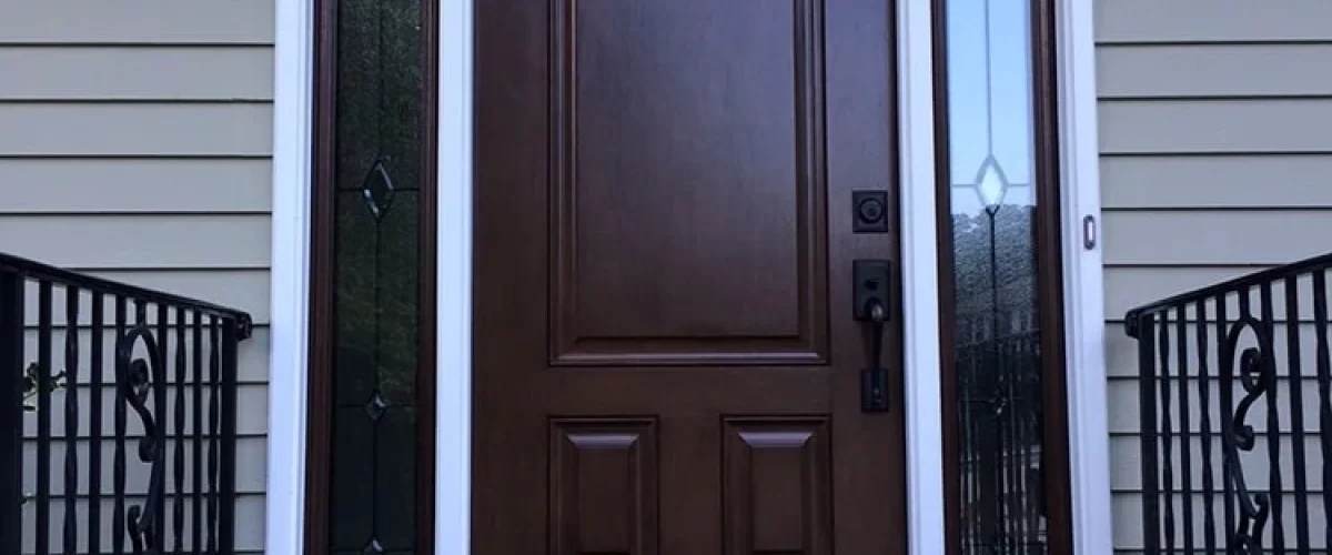 large dark wood entry door with glass side panels