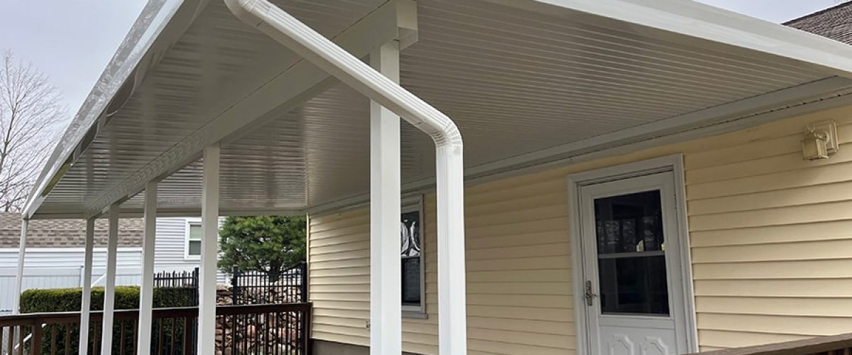 patio cover installed on a yellow house with white accents