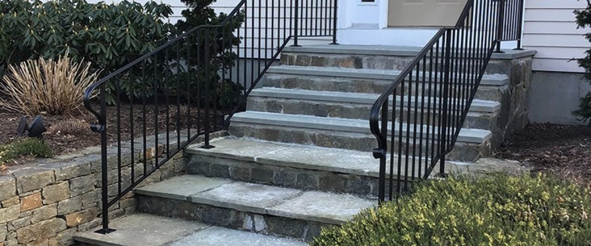 right angle of new wrought iron railing on tan house