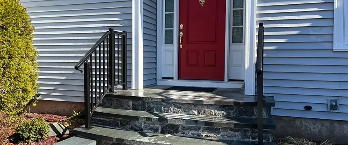 railing installation on blue house with red door