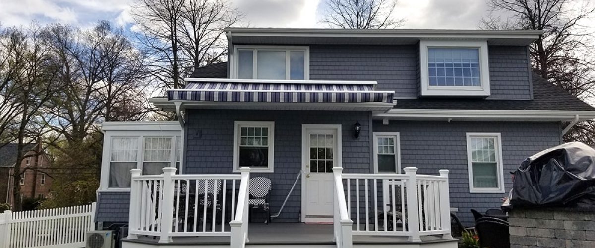 blue and white striped retractable awning installed above porch