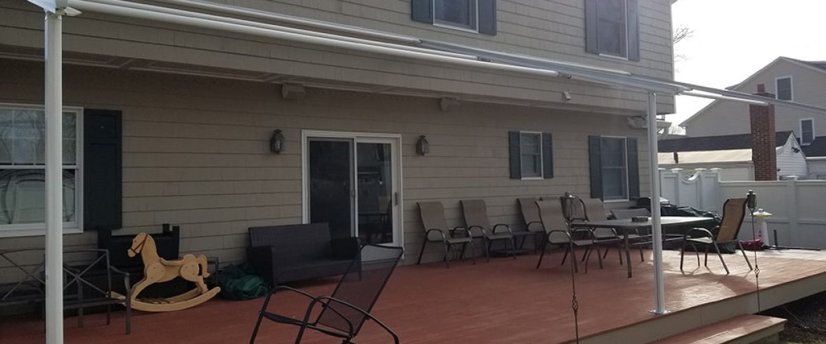 green retractable awning installation on yellow house