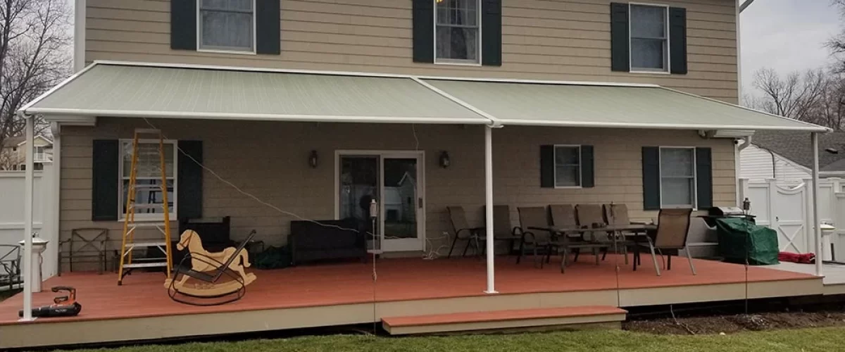 striped retractable awning installation on house