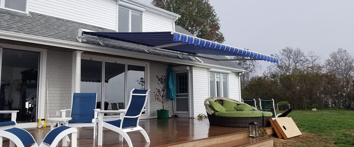 blue retractable awning installation on house
