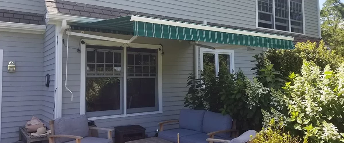 green retractable awning installation on house