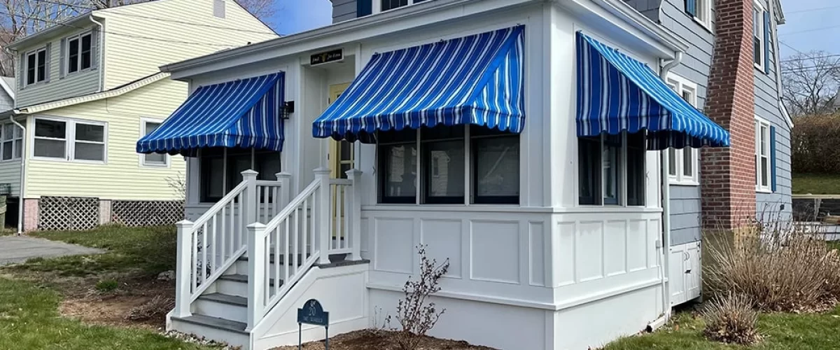 blue fabric window canopies covering windows in front of a house