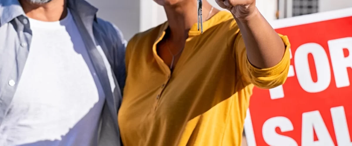 man and woman in front of new home holding their keys