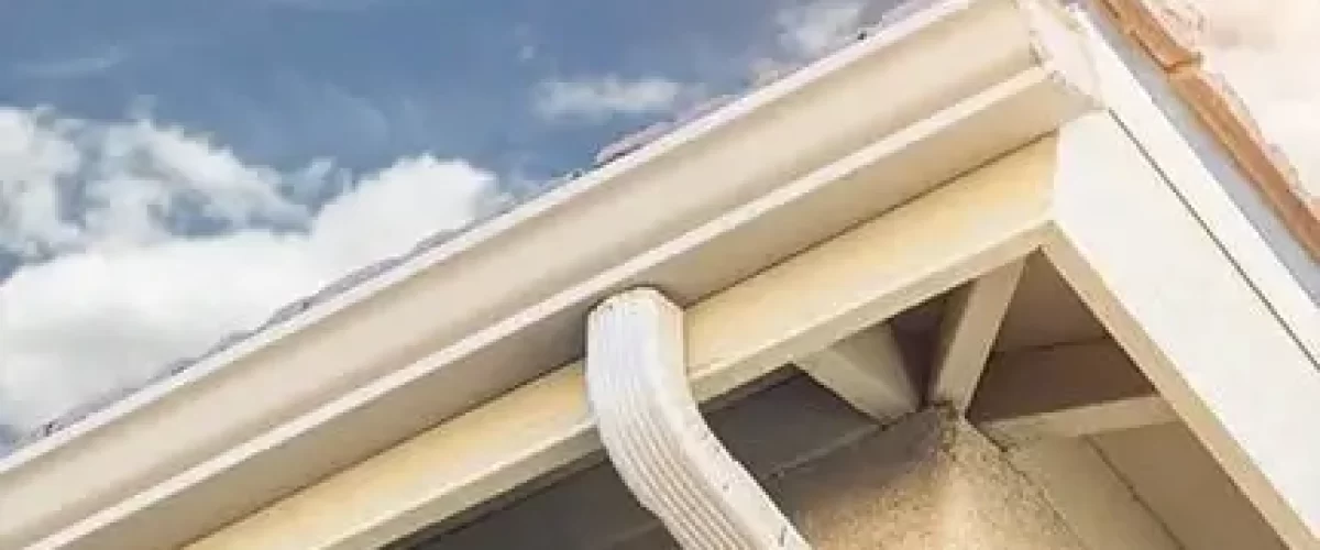 corner of roofline showing aluminum gutter and downspout