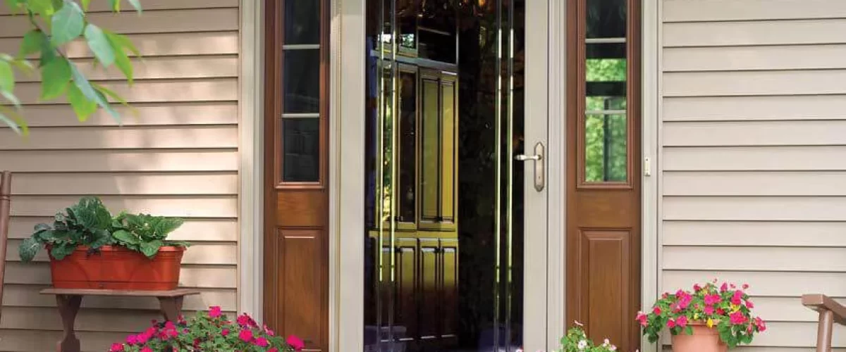 tan storm door on a tan house with wood side panels